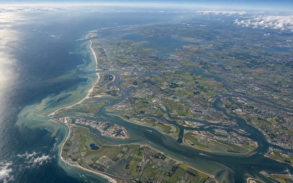 High-altitude Earth-observation view of a coastal river delta and surrounding landscape